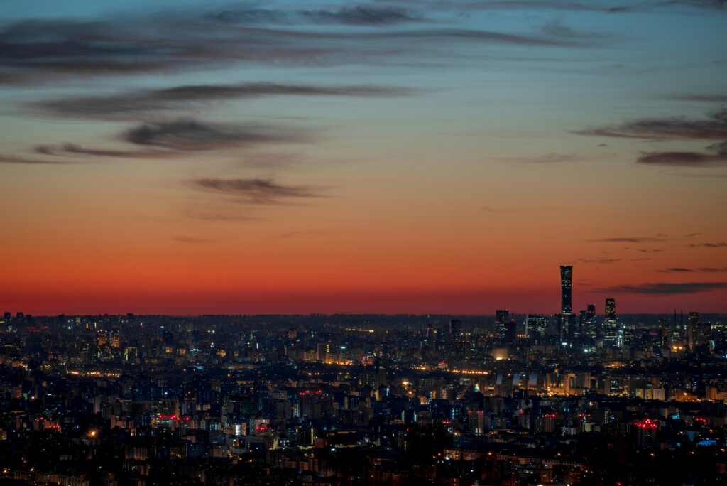 A city skyline at sunset with buildings silhouetted against a golden sky.